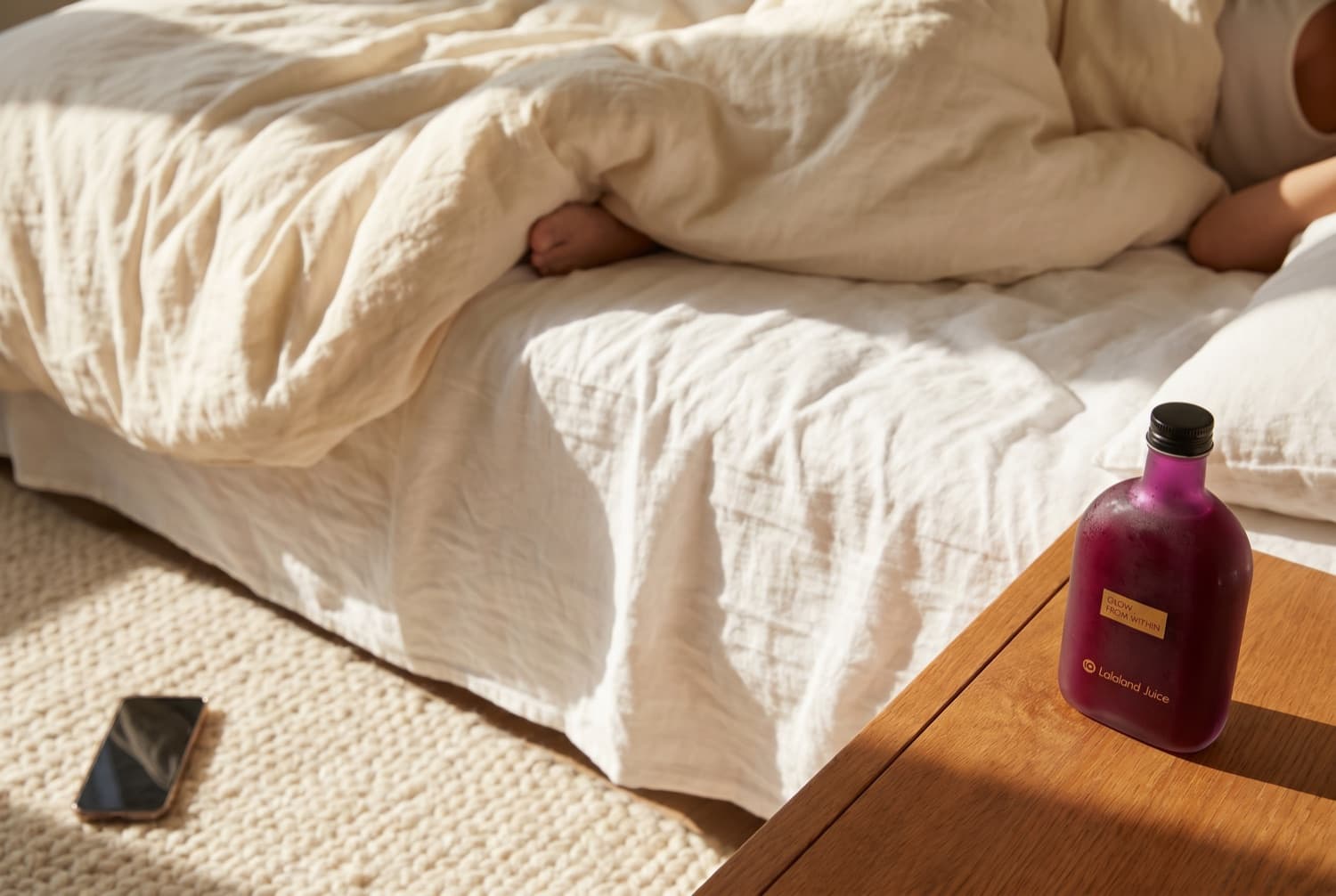 A sunlit bedroom in the morning, a Lalaland bottle on the nightstand